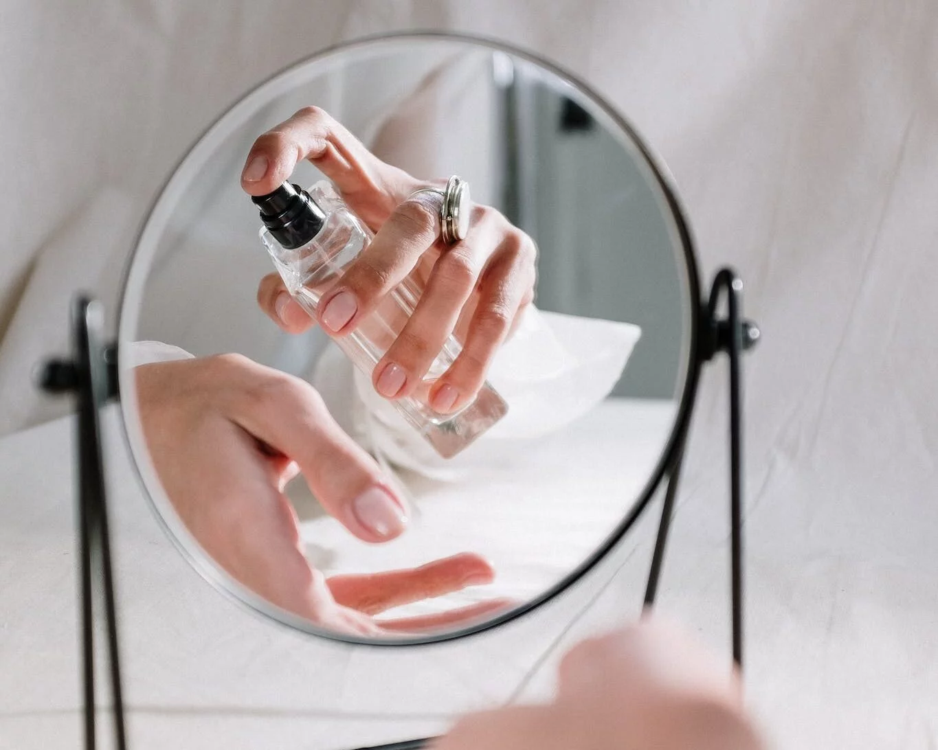 Osoba držiaca okrúhle zrkadlo z číreho skla